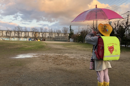 雨の中傘をさす女の子