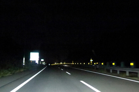 道路の標識が車のライトを反射している様子